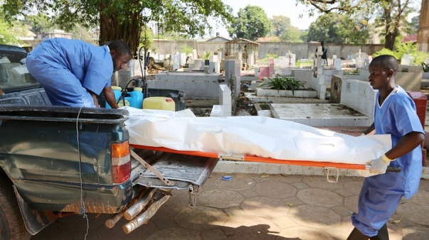 Des membres d'un personnel médical de la croix-rouge en train de transporter un corps