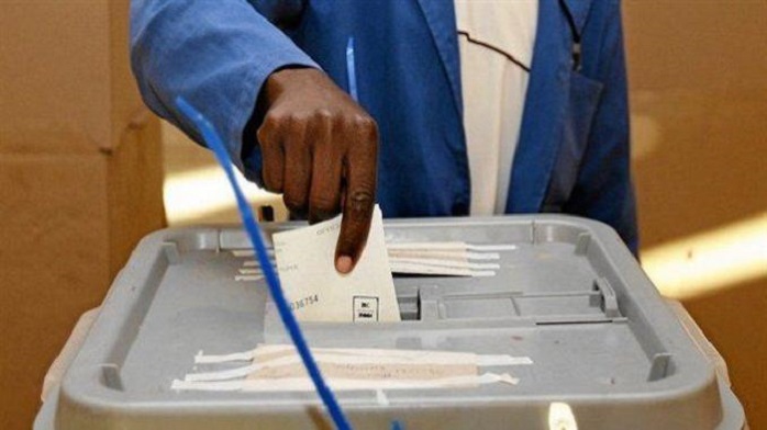 Un homme en train de glisser son bulletin dans l'urne