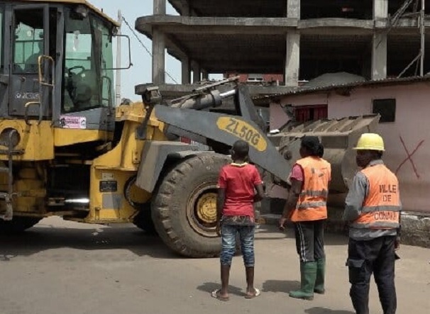 Un bulldozer en pleine action en train de déguerpir des emprises au bord de la route (image d'illustration)
