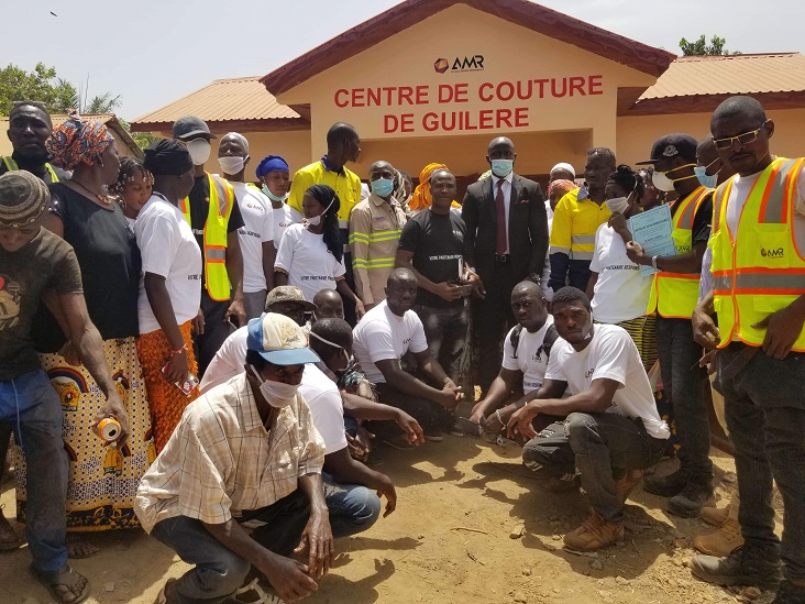 Photo de famille devant le centre de couture de Guiléré offert par l'Alliance minière responsable (AMR)