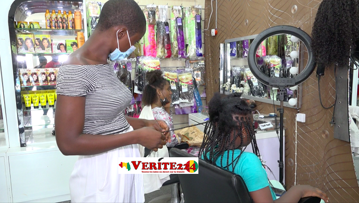 Une femme en train de coiffer une cliente dans un salon de coiffure