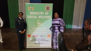 Madame Marie Gomez devant une affiche de la conférence internationale sur la traite des personnes